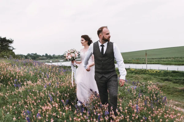 Nygifta promenad utomhus på deras bröllopsdag — Stockfoto