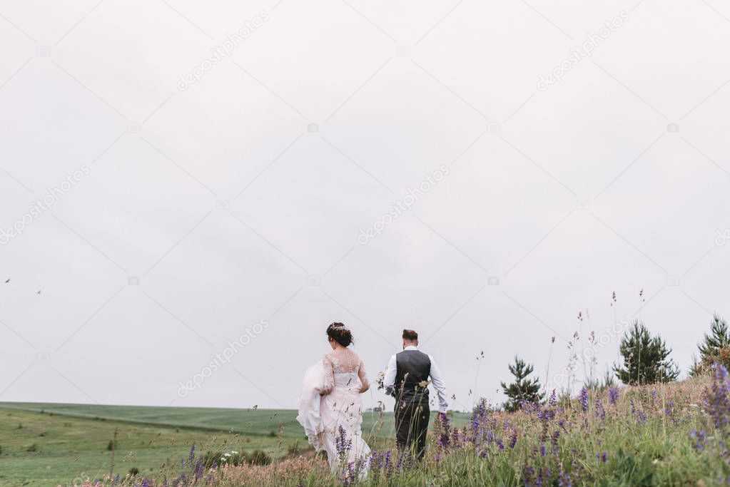 Newlyweds walk outdoors on their wedding day
