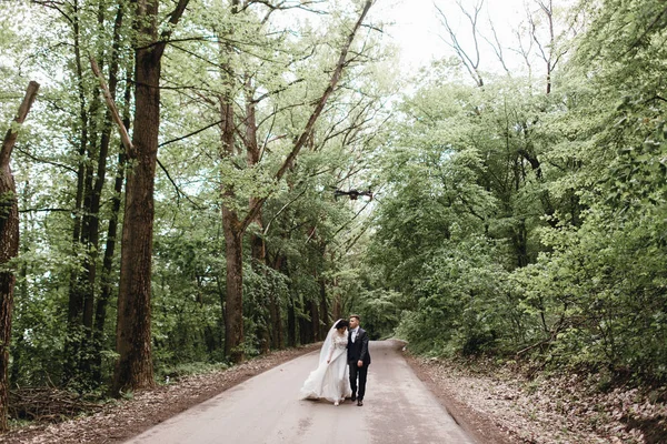 美しい結婚式のカップルが道を歩いてのロマンチックな瞬間を楽しむ — ストック写真
