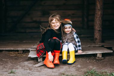 Gülümseyen çocuklar tahta bankta oturan