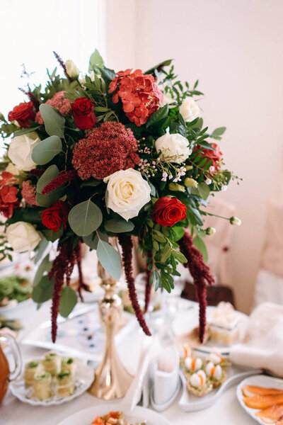 Closeup view of flower bouquet and appetizers on blurred background