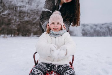 Atlı kızak ve ablası arkasında oturan küçük kız kardeşi