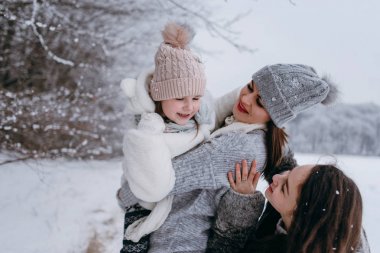 Anne küçük kızı elinde tutan ve birlikte eğlenmek