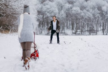 Bir anne ile kış Park'ta yürüyordunuz ve küçük kızı halletme kızları arkadan görünüş