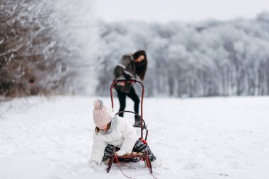 Atlı kızak ve yaşlı kız eğleniyor arka plan üzerinde oturan küçük kız