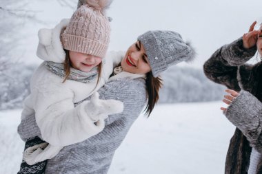 Anne küçük kızı elinde tutan ve birlikte eğlenmek