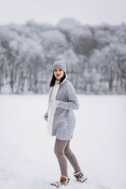 Park kar yağışı yürüyüş kış giysileri giyen kadın yan görünüm