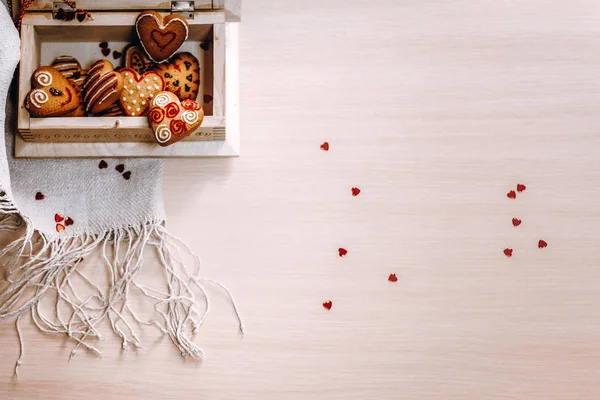 Decorative composition with heart cookies served in wooden box on beige wooden background