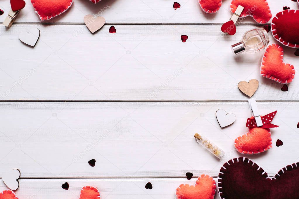 Valentines day background with red hearts and perfume on wooden planks background