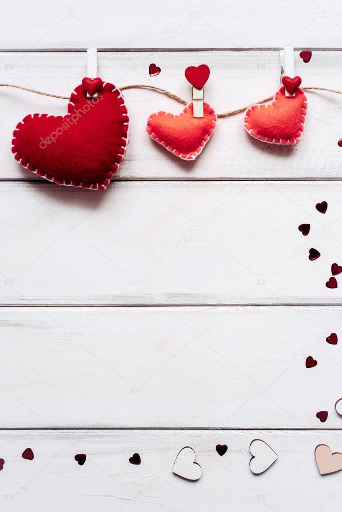 Composition of three red hearts attached with clothespins to a rope