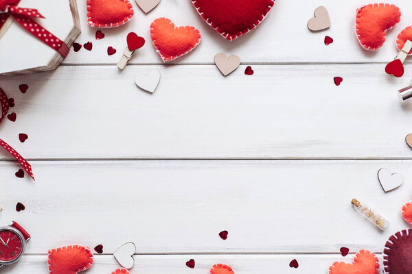 Декоративная композиция с красными сердцами и блестящими сердцами на фоне деревянных досок, посвященная Дню Святого Валентина
.