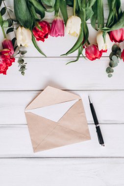 Zarf kağıt, kalem ve arka plan üzerinde laleler açtı