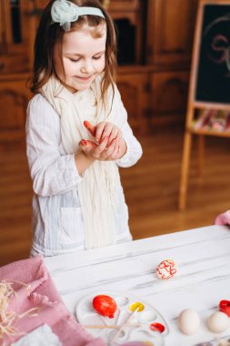 Gülümseyen ve boyalı Paskalya yumurtaları seyir küçük kız.