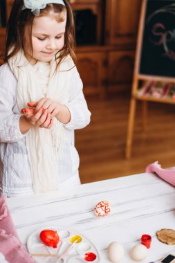 Gülümseyen ve boyalı Paskalya yumurtaları seyir küçük kız.