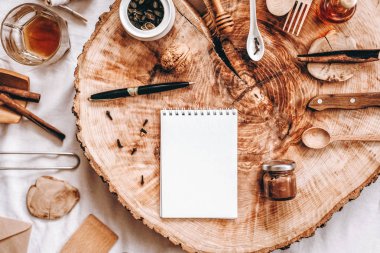 Defter, kalem ve farklı öğeleri ile sawed ahşap arka plan üzerinde Üstten Görünüm