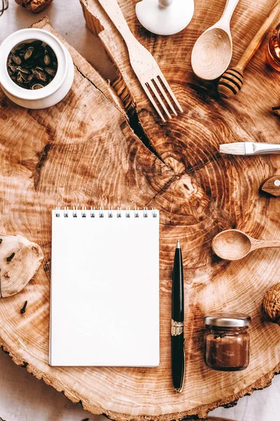 Vista Superior Madera Aserrada Con Cuaderno Bolígrafo Accesorios Cocina Sobre —  Fotos de Stock