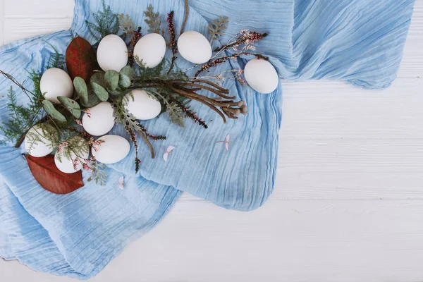 在蓝色披肩上放置有芽和茎的白色卵组成 — 图库照片