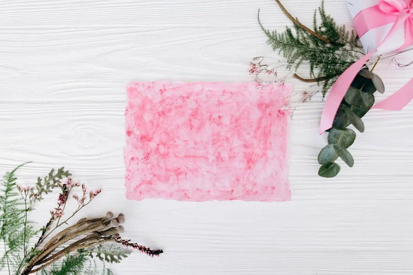 植物成分 粉红色纸和礼品盒白色木质背景 — 图库照片