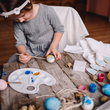 Sevimli kız boyama Paskalya yortusu yumurta rahat Oda ahşap masada kısmi görünümünü