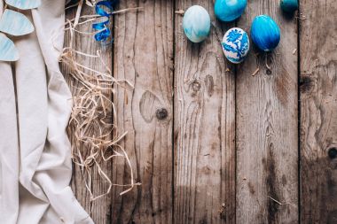 Mavi yumurta yığın sağ tarafında, bez, şerit ve saman ahşap plakalar arka plan üzerinde döşeme Üstten Görünüm
