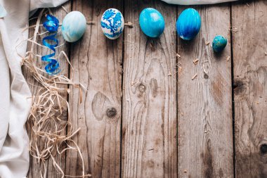 Mavi yumurta satır üstte, bez, şerit ve saman ahşap plakalar arka plan üzerinde döşeme Üstten Görünüm
