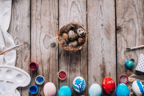 彩色鸡蛋的最高视图 巢与鹌鹑蛋 礼品盒和油漆的木板背景 — 图库照片