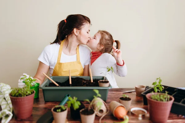 Mother Kissing Little Daughter While Transplanting Sprouts — Stock Photo, Image