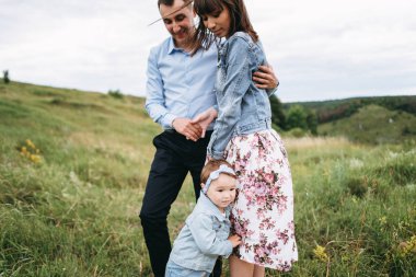 Koca eşi ve küçük kızı yakınındaki çayır üzerinde duran sarılma