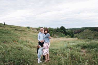 Koca eşi ve küçük kızı yakınındaki çayır üzerinde duran sarılma