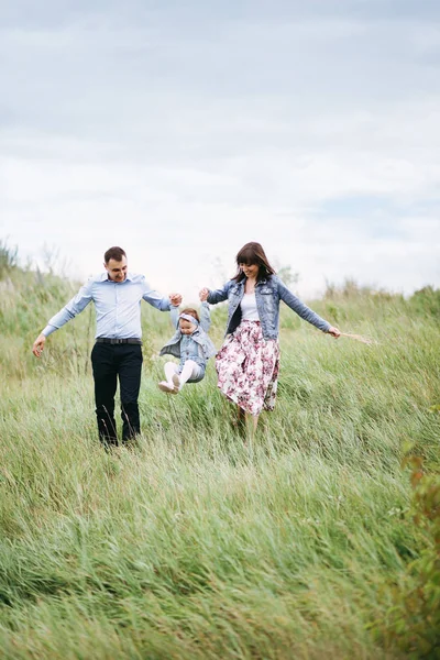 Família Andando Prado Com Pequena Filha Mãos Dadas Enquanto Salta — Fotografia de Stock