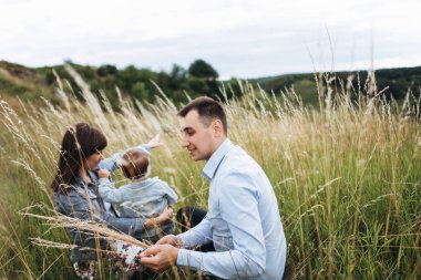 Çimenlerin üzerinde oturan ve kızı sarılma anne