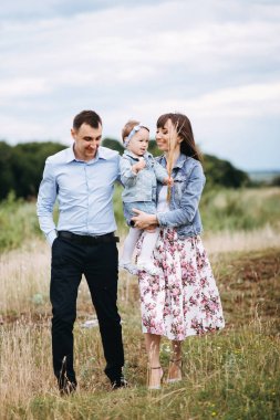 Aile gülümseyen ve birlikte sahada yürüme