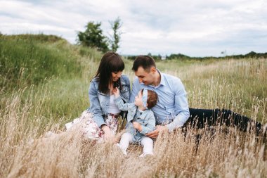 Genç aile buğday alanında gri gün oturup önden görünümü