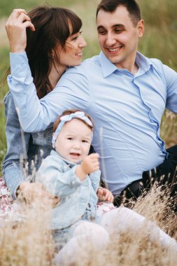 Alanında oturup ve küçük kızı buğday ile oynarken süre flört anne