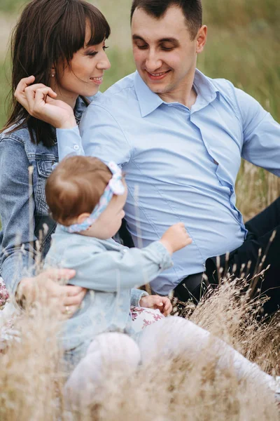 Föräldrar Sitter Fältet Och Flirta Medan Lilla Dotter Leker Med — Stockfoto