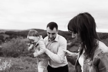 Siyah ve beyaz fotoğraf adam holding kızının el ve yakınındaki yürüyen kadın