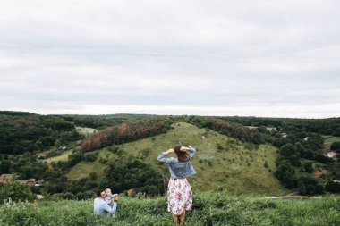 Kız ve kadın manzarayı Hill ile çimlerde oturan adam arka görünümü