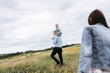 Arkadan görünüş genç aile birlikte gri gün şeytan içinde yürüyüş