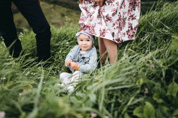 Malda Liten Flicka Sitter Gress Och Föräldrar Står Bakom — Stockfoto