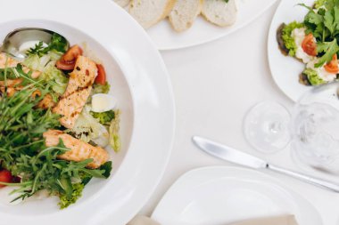 Festival salata üstten görünüm beyaz tabaklar, ekmek, cam ve bıçak