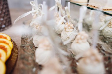 Pembe çiçekler ve şiş üzerinde beyaz yay süslenmiş beyaz pasta çıkar closeup