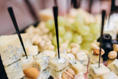 Closeup incelik peynir şişleri, üzüm, fıstık, kaju fıstığı, badem ve zeytin iştah açıcı tablo için