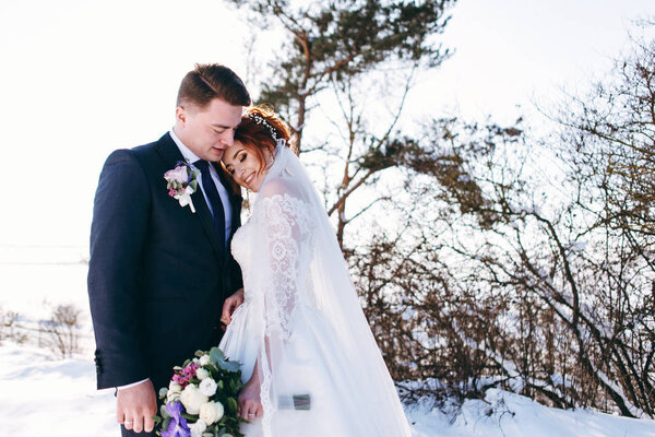 Romantic newlyweds hugging outside in winter day 