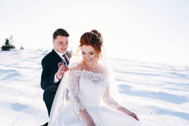 Çayır tarafından yürüyüş ve having fun kış günü damat ile gelin