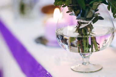 Cam vazoda çiçekler closeup tablo üzerinde yanan muma kazanmak 