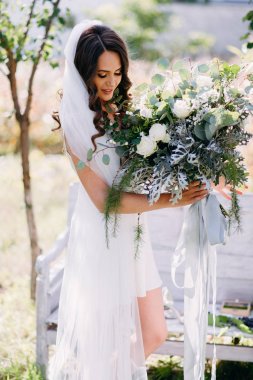 Sabahlık düğün buket bahçede poz ile gülümseyen gelin portresi