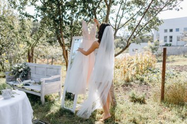 Gelin gelinlik dalı bahçesinde üzerinde asılı