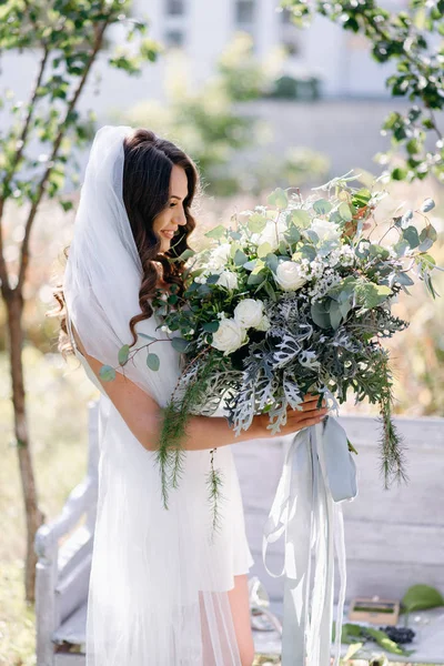 結婚式の花束の庭でポーズとネグリジェで笑顔の花嫁の肖像画 — ストック写真
