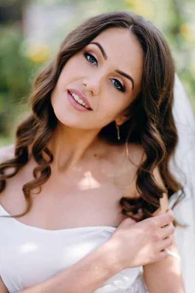 Bride with wavy hair smiling and looking at camera