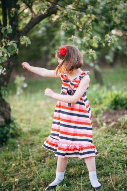 Bahçede dans çizgili elbiseli kız